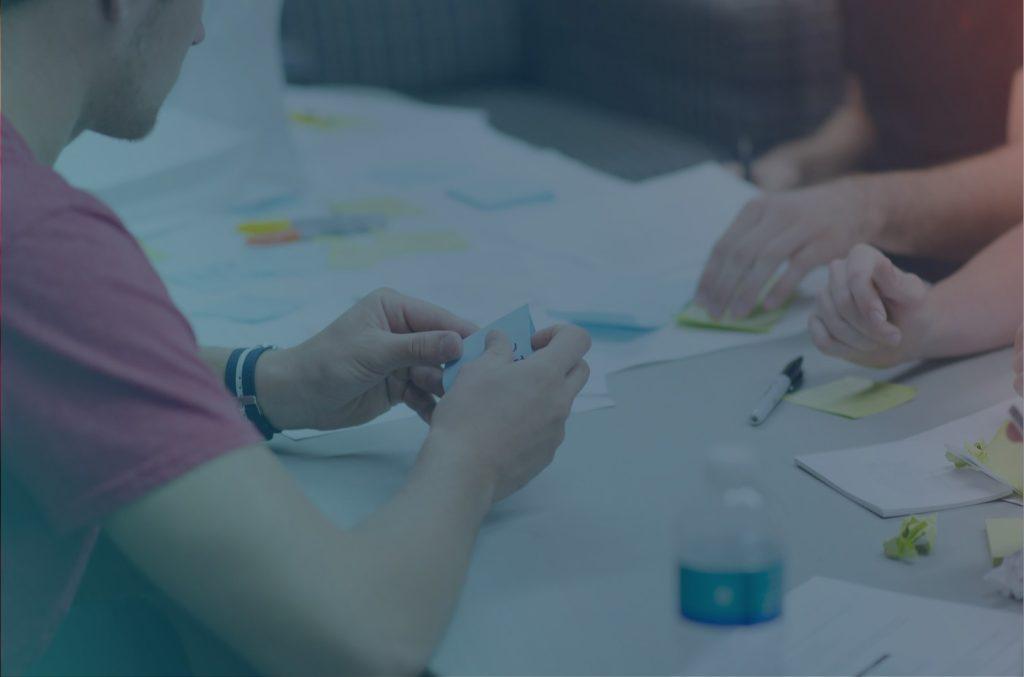 Employees of a software company having a workshop and are holding post-its in their hands.