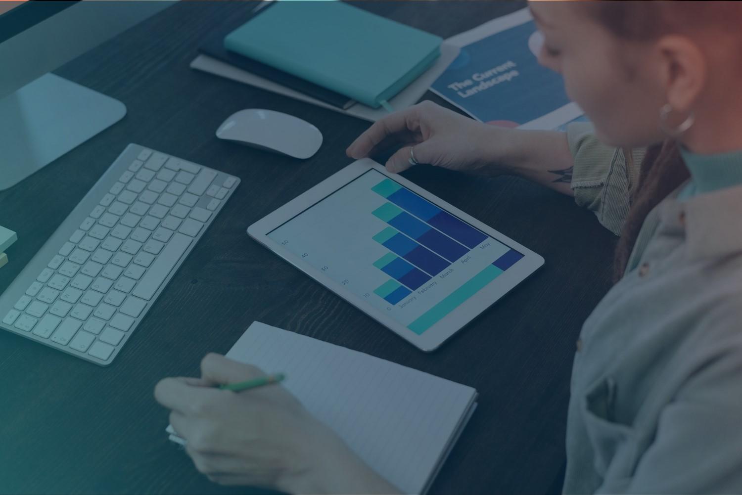 A woman is checking diagrams about marketing and making notes.