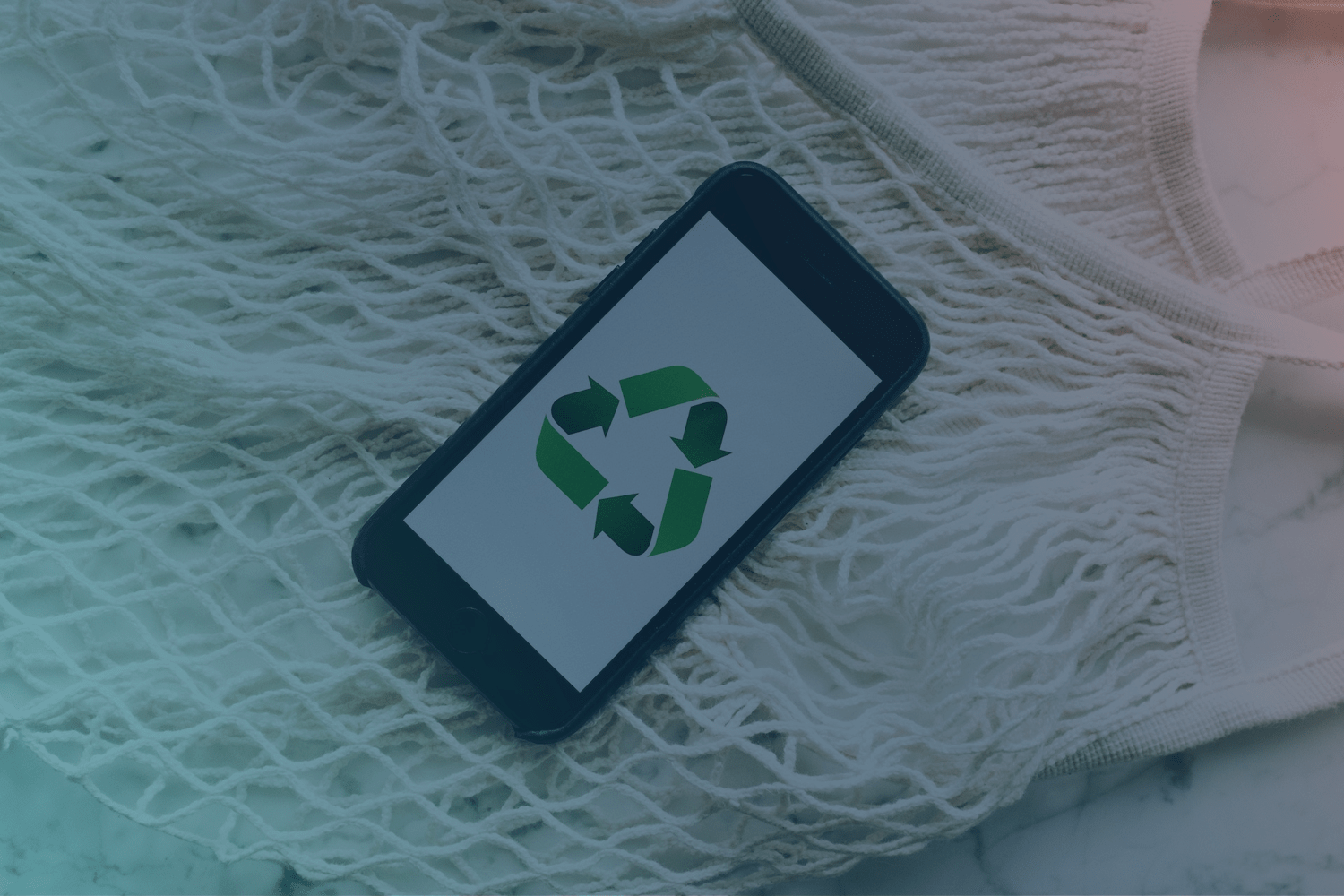 A smartphone with a green recycling symbol on the display.